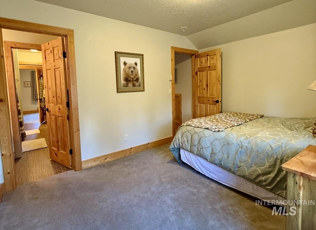 Bedroom with lofted ceiling, a textured ceiling, and carpet floors