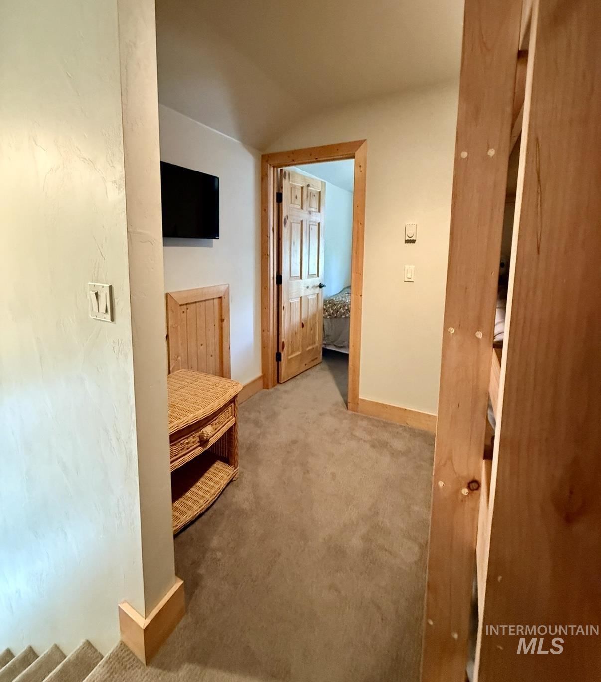 Corridor featuring carpet floors and vaulted ceiling