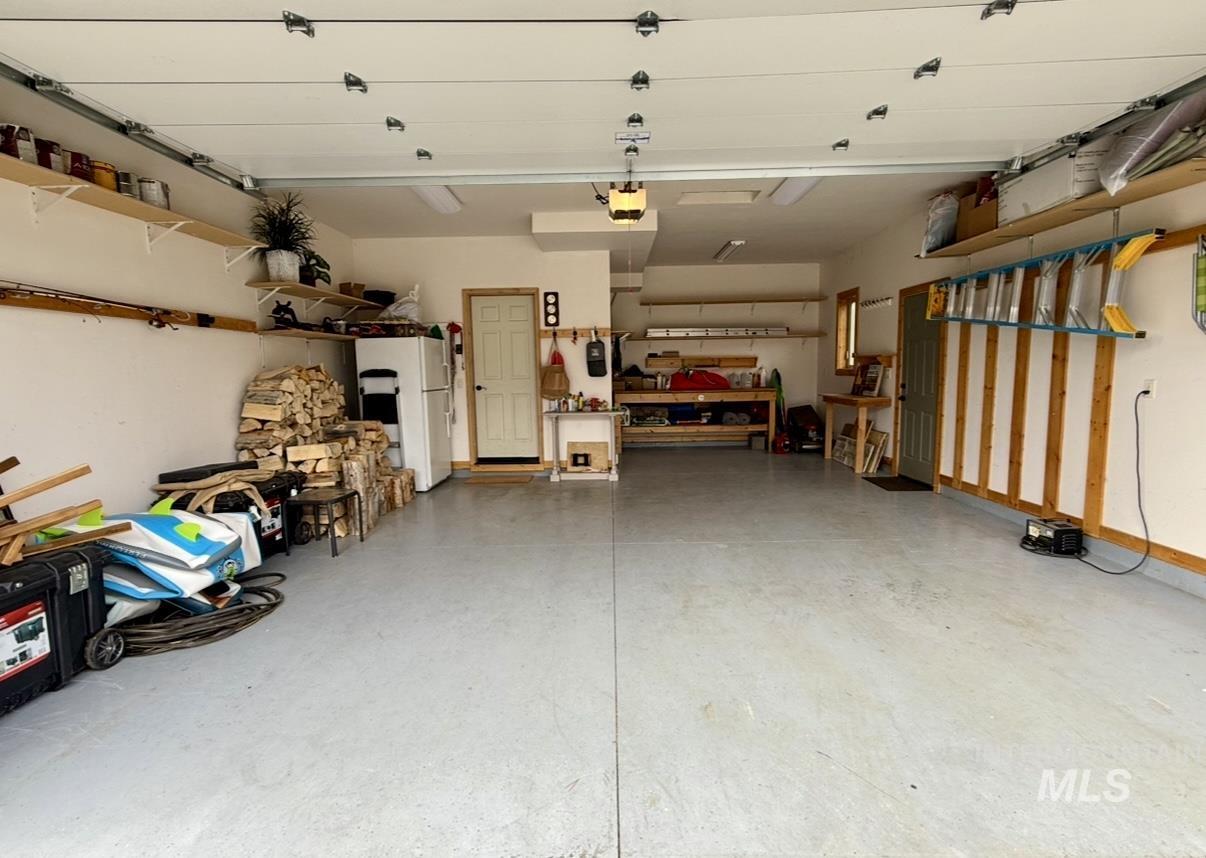 Garage with freestanding refrigerator and a workshop area