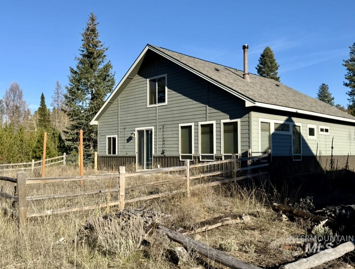 Rear view of house featuring a shingled roof