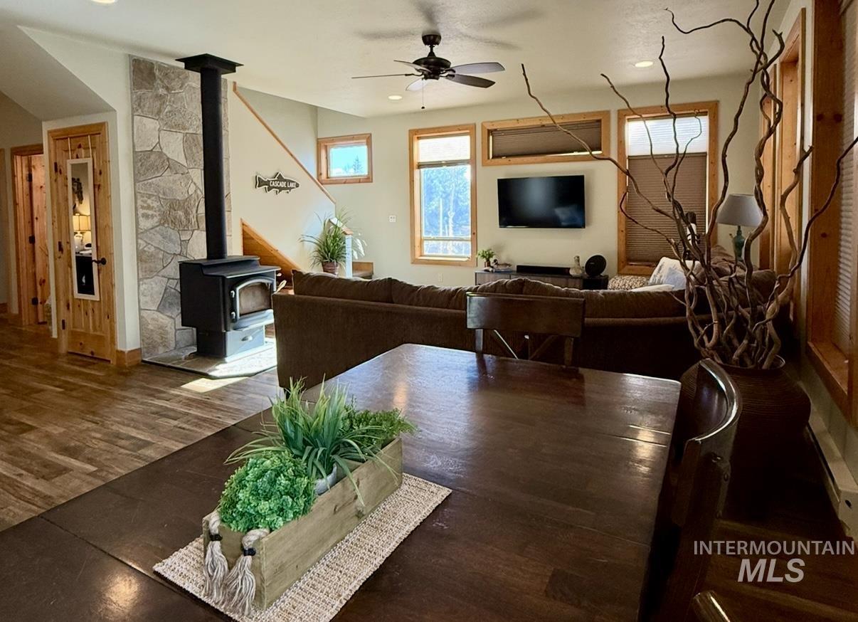 Living area with a wood stove, ceiling fan, dark wood-style floors, and recessed lighting