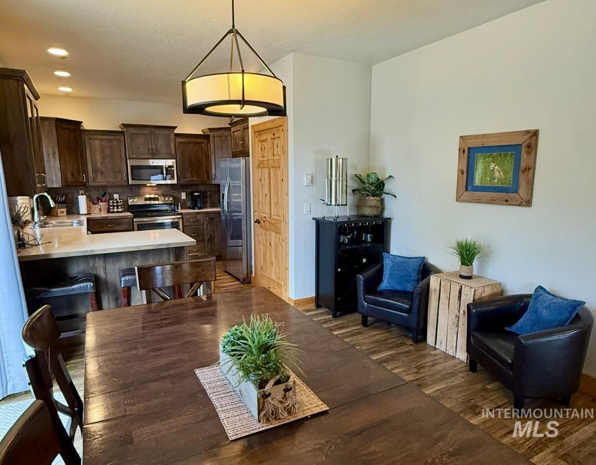 Dining space featuring dark wood-style floors and recessed lighting