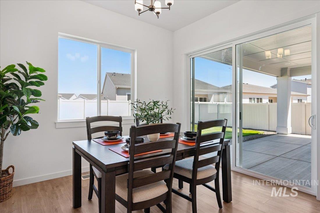 Dining area featuring a chandelier, light wood-style floors, and plenty of natural light