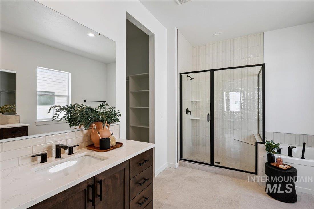 Bathroom with a shower stall, vanity, recessed lighting, decorative backsplash, and a bath