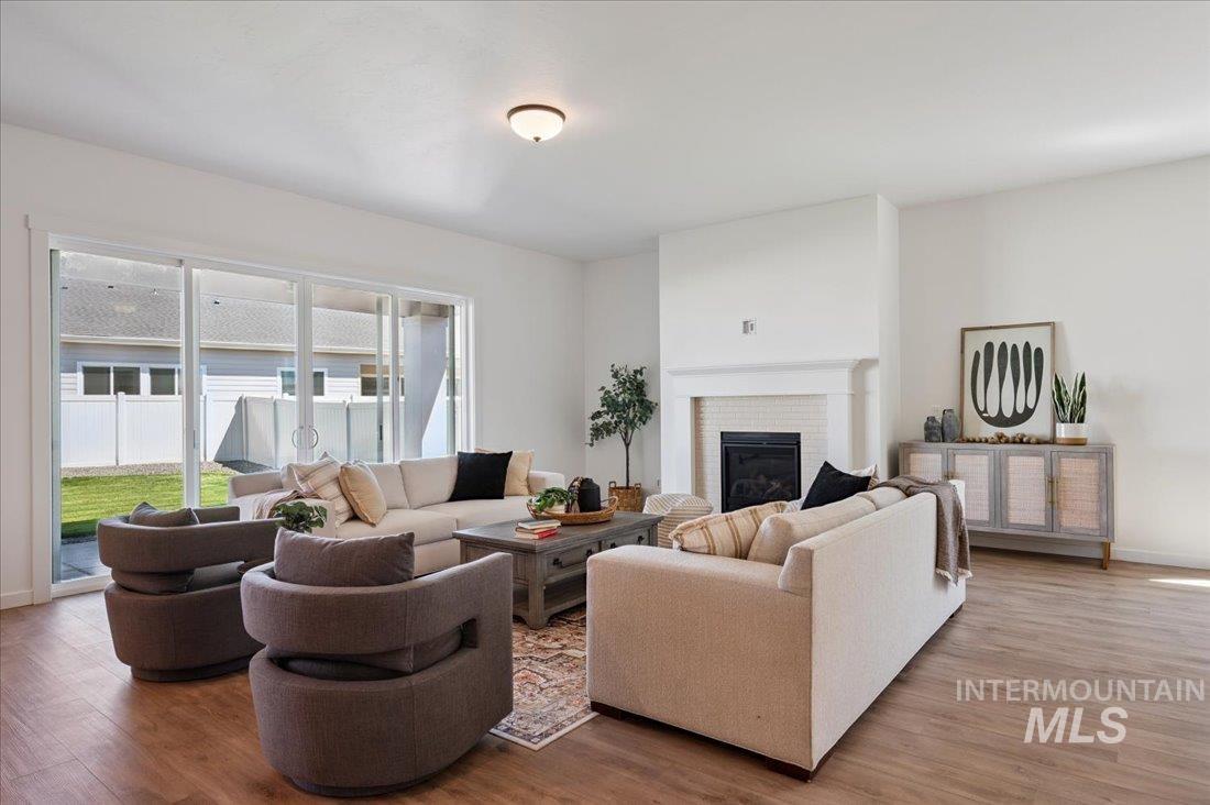 Living area featuring light wood-style floors and a brick fireplace