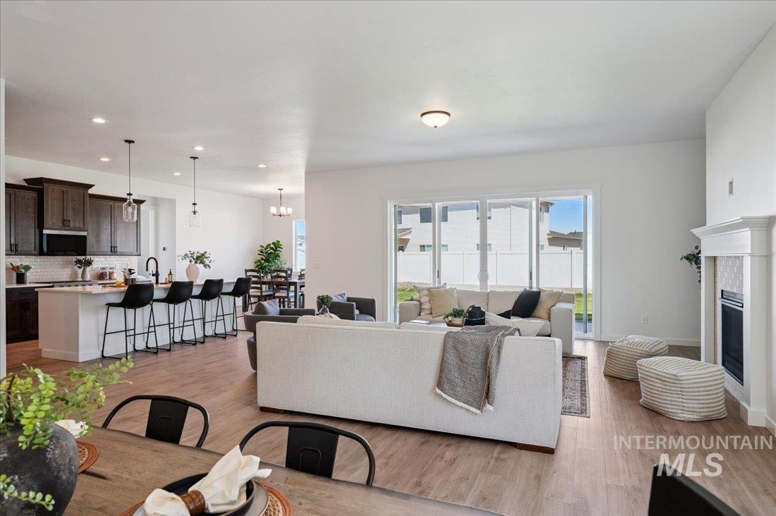 Living room featuring light wood-style floors, a chandelier, recessed lighting, and a tile fireplace