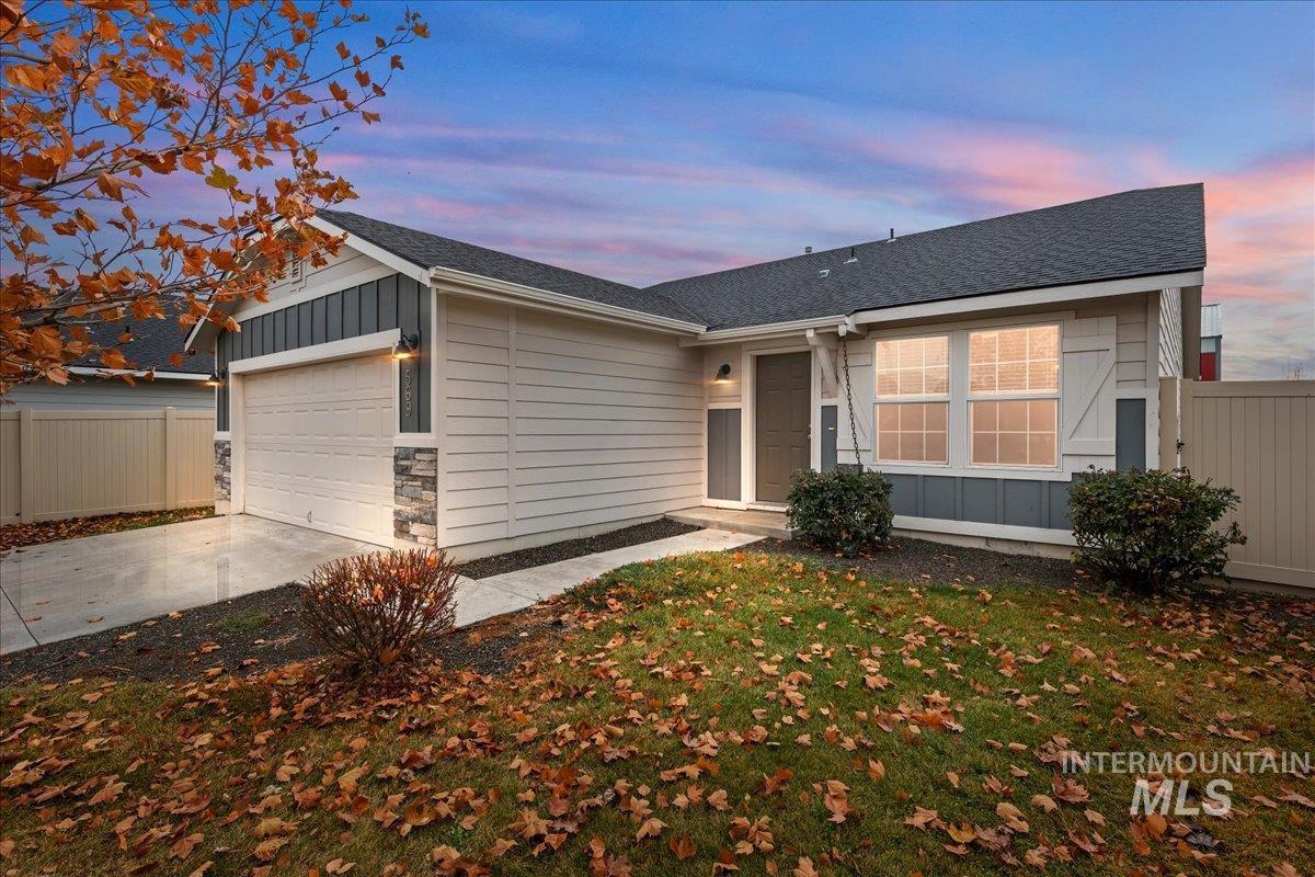 Ranch-style home featuring roof with shingles, board and batten siding, driveway, and a garage
