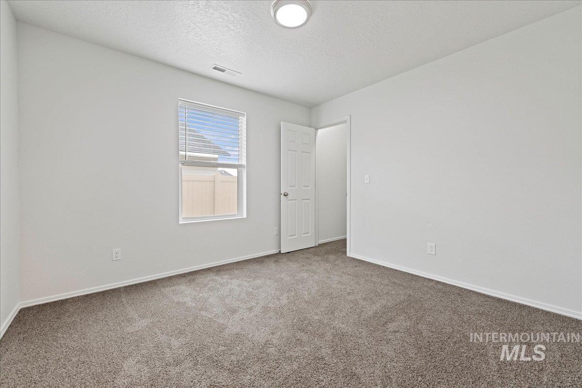 Spare room with a textured ceiling and carpet flooring