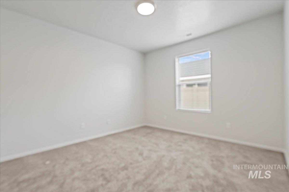 Carpeted spare room with baseboards