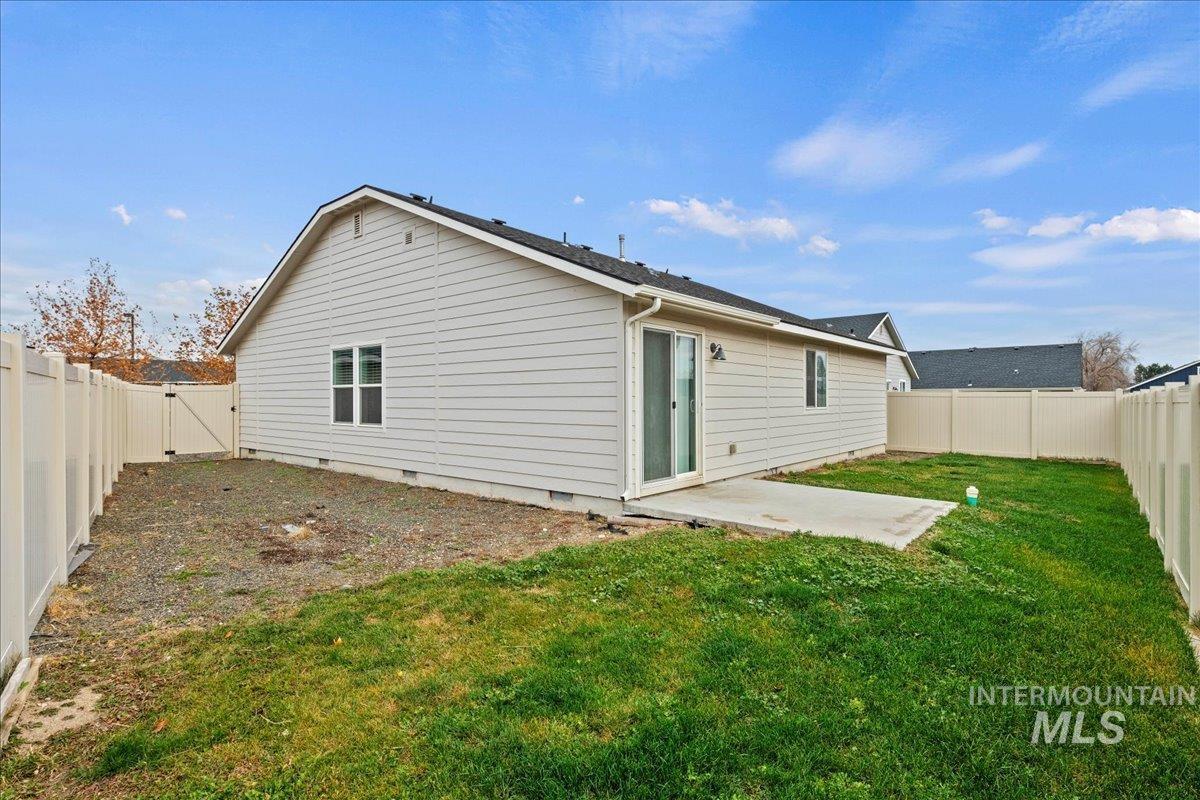 Rear view of property with a fenced backyard, a patio, crawl space, and a gate