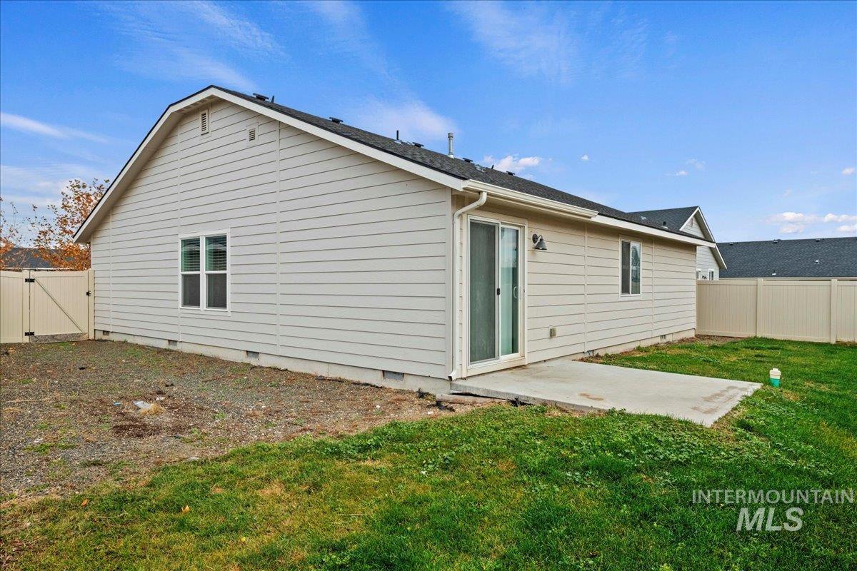 Back of house featuring crawl space, a fenced backyard, a patio area, and a gate