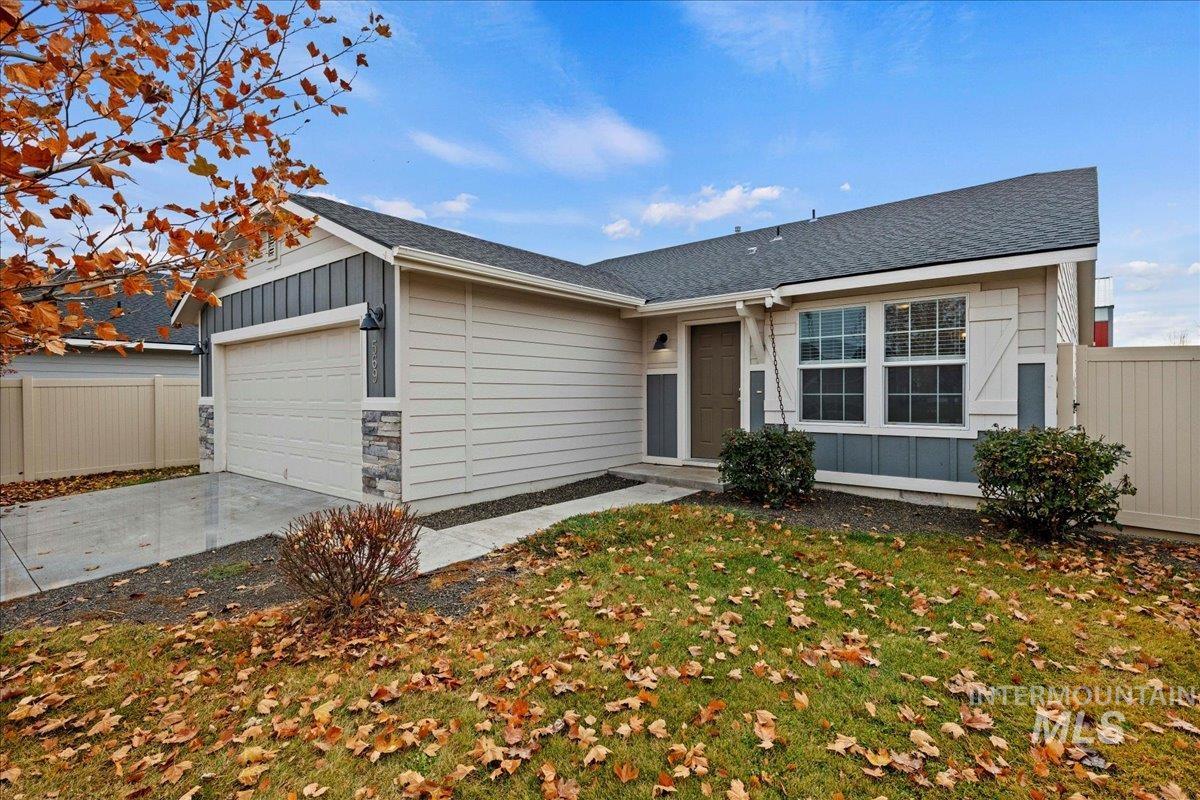 Ranch-style house featuring board and batten siding, a shingled roof, and a garage