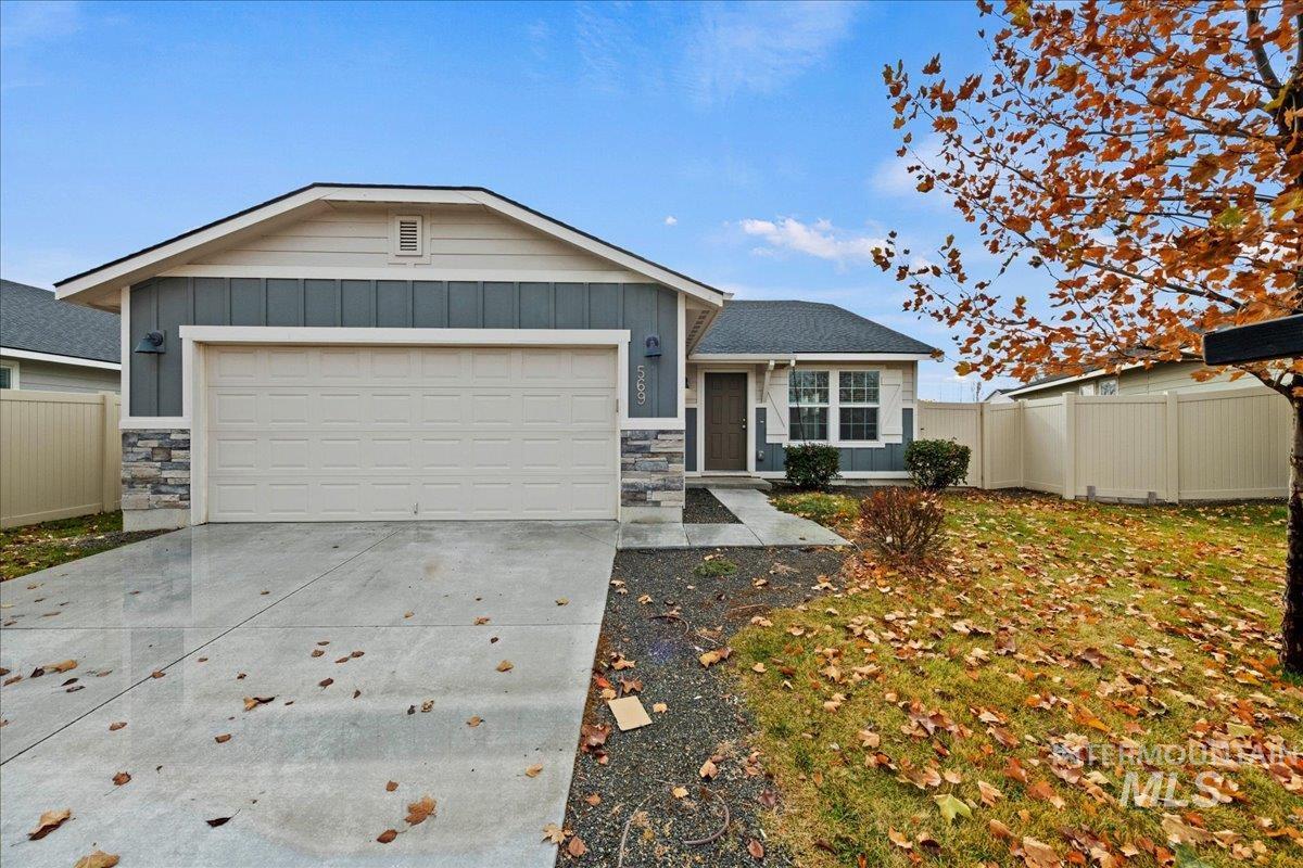 Ranch-style house featuring board and batten siding, stone siding, concrete driveway, and a garage