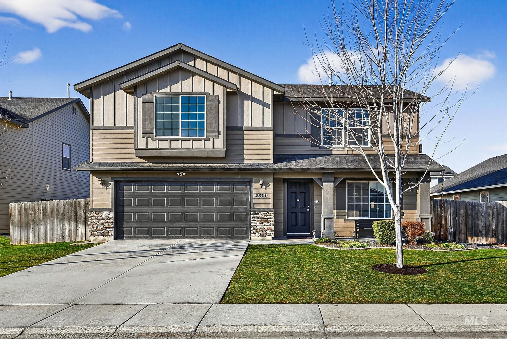 View of front of house featuring board and batten siding, stone siding, concrete driveway, a garage, and a shingled roof