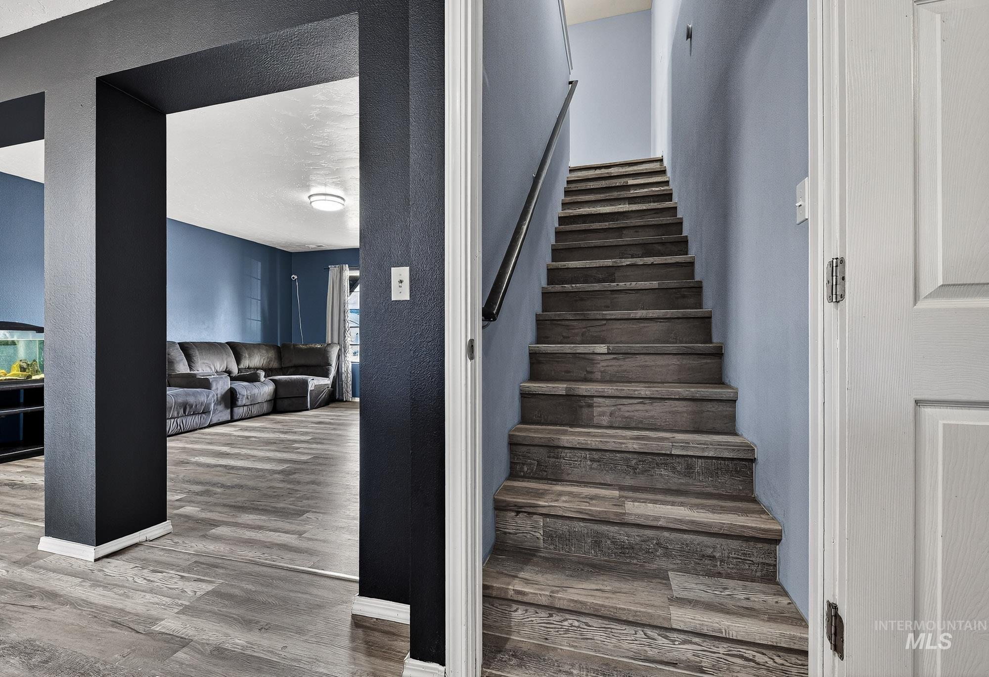 Stairs featuring laminate finished floors and a textured wall