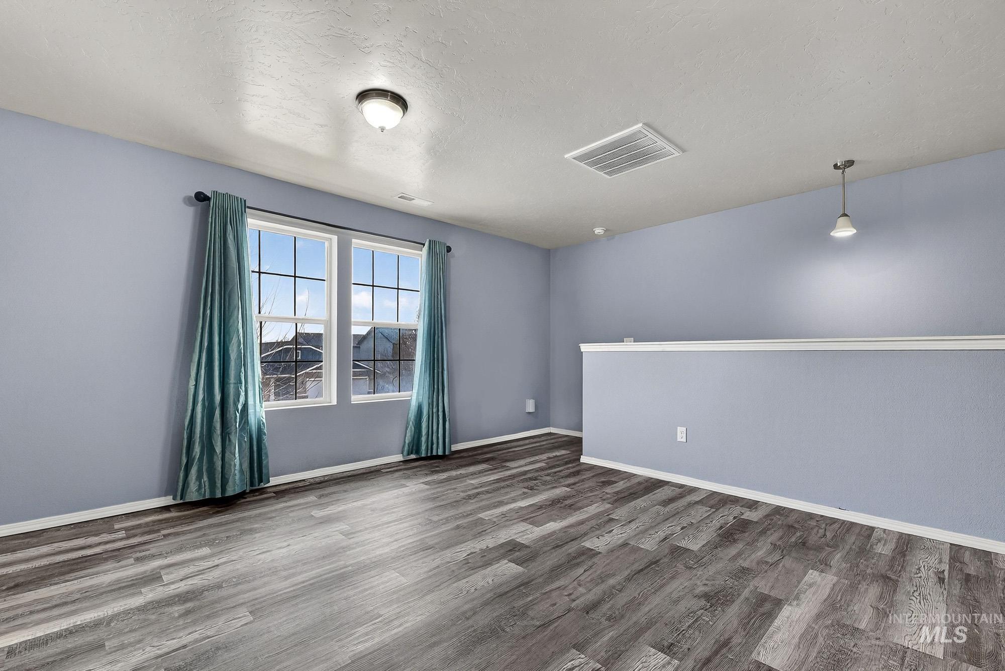 Family room featuring wood like laminate finished floors and a textured ceiling