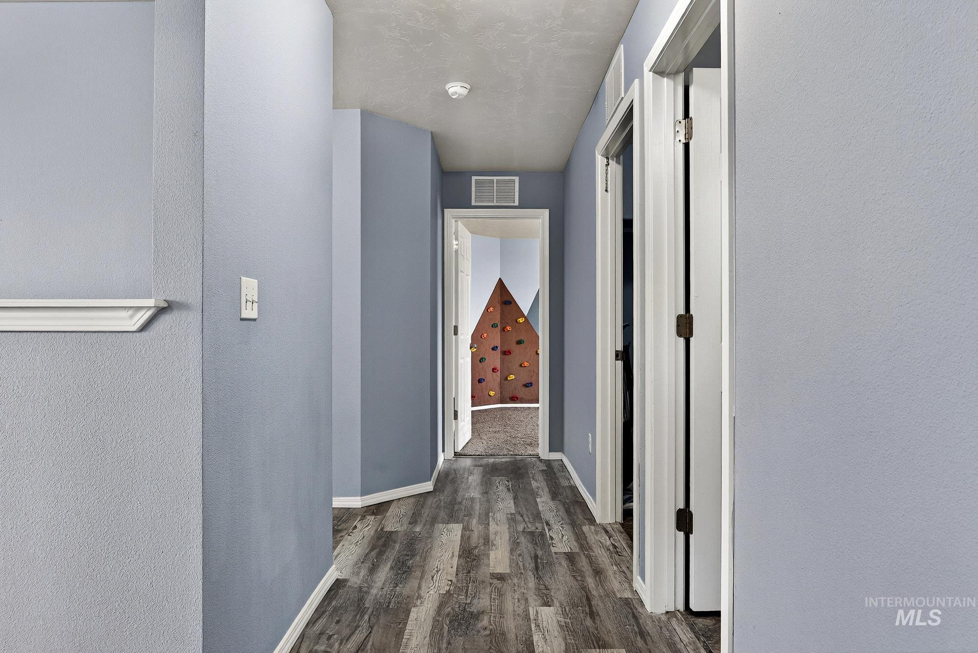 Corridor with laminate wood-style floors and a textured wall