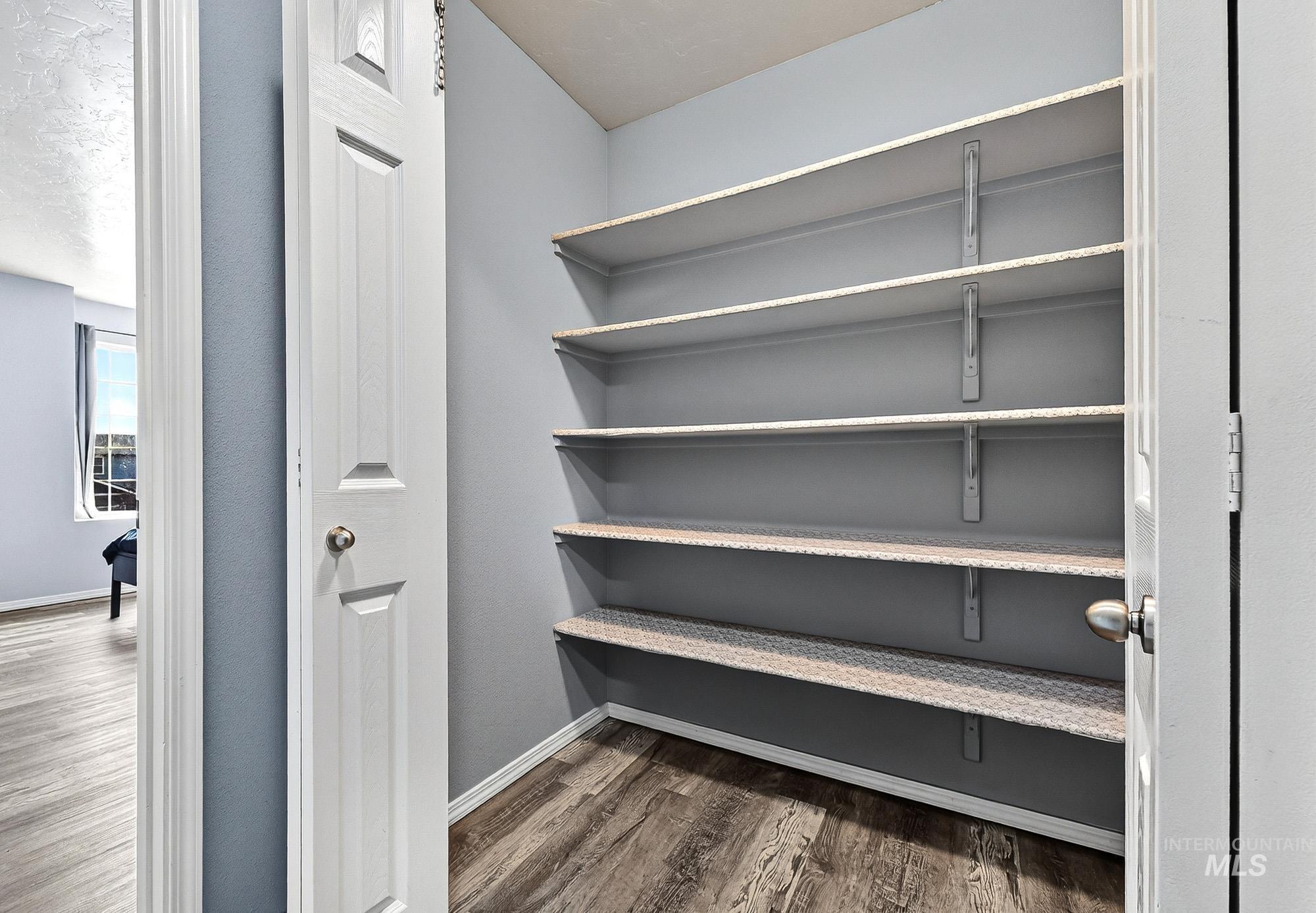 View of large storage closet with laminate finished floors