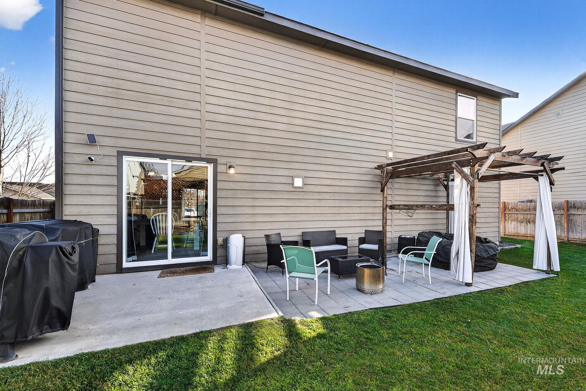 Back of property with a patio area, a pergola, and a fire pit