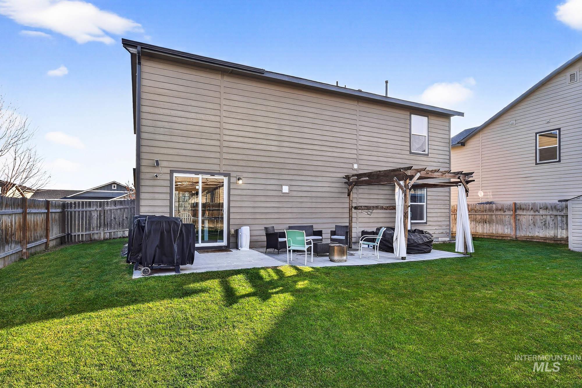 Rear view of house with a patio, a fenced backyard, and a pergola