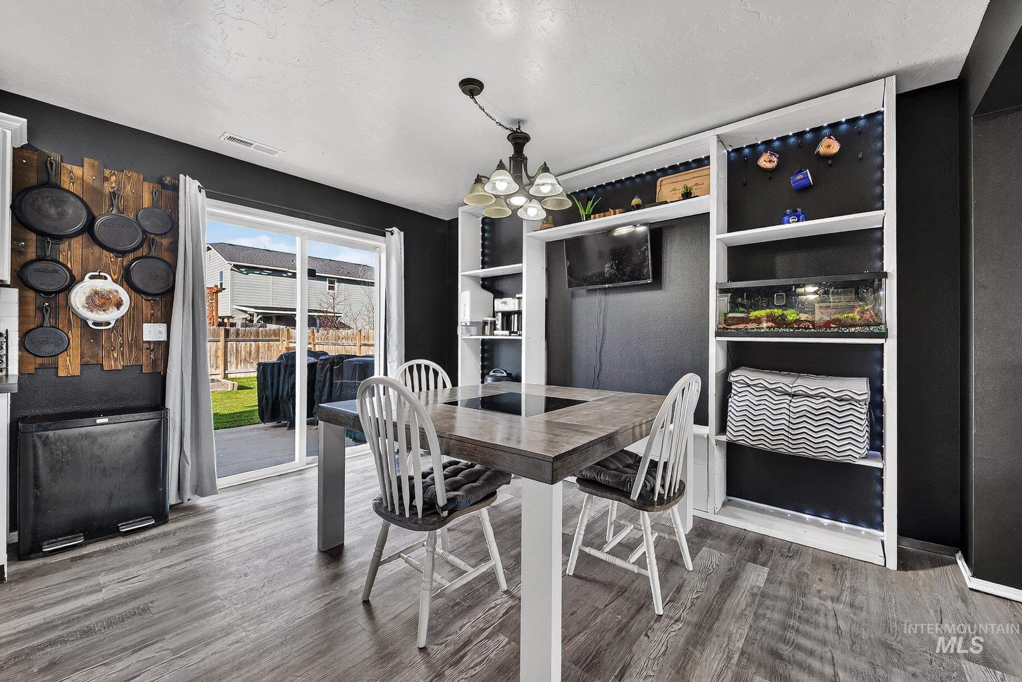 Dining area featuring a chandelier and wood like finished laminate floors