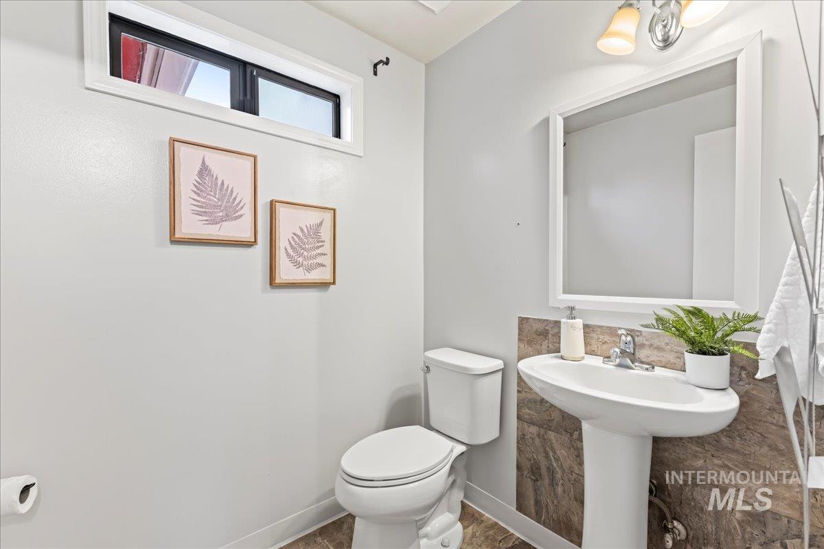 Half bathroom with toilet and baseboards