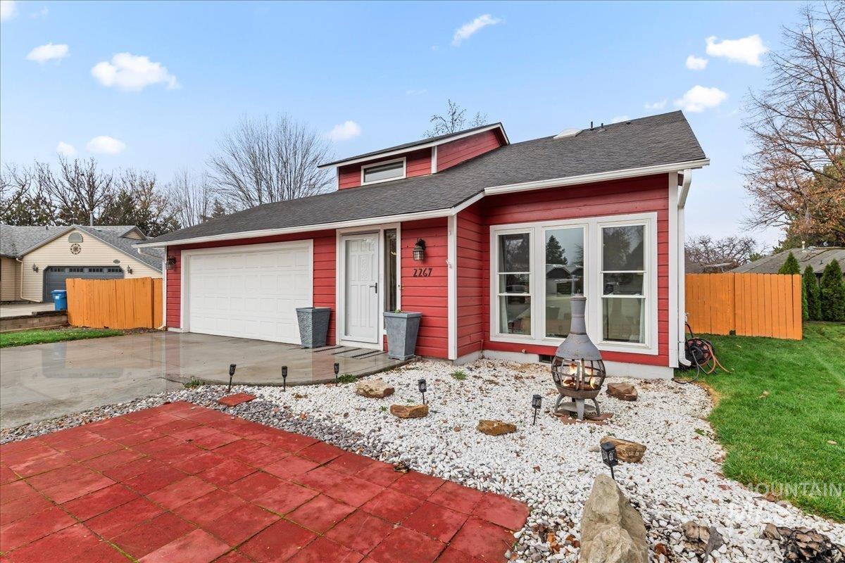 View of front of property featuring driveway, a garage, and a shingled roof