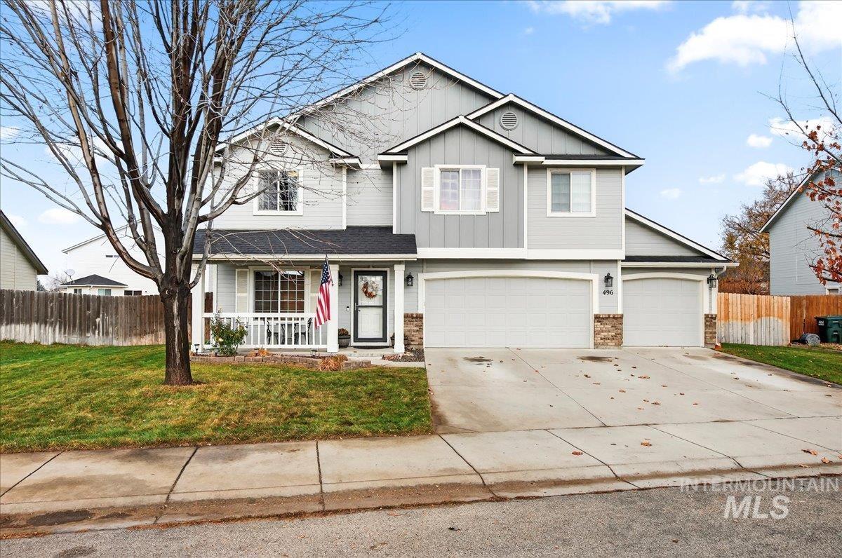 Traditional-style house featuring covered porch, concrete driveway, board and batten siding, and a garage
