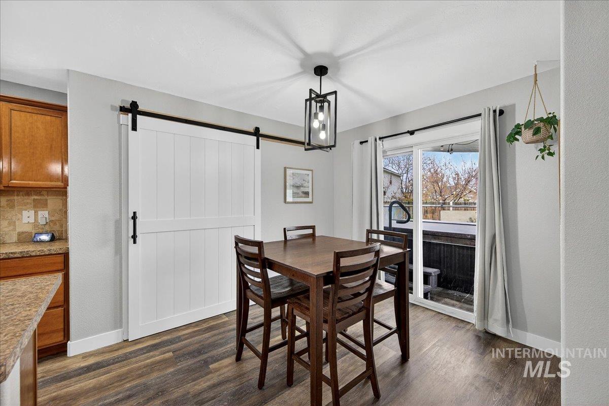 Dining room featuring dark wood-type flooring and a barn door