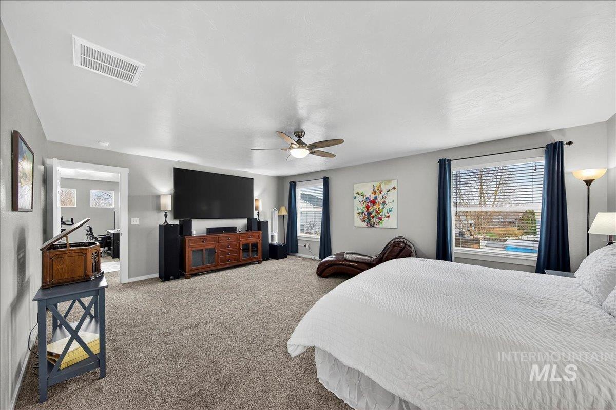 Carpeted bedroom featuring a ceiling fan and baseboards