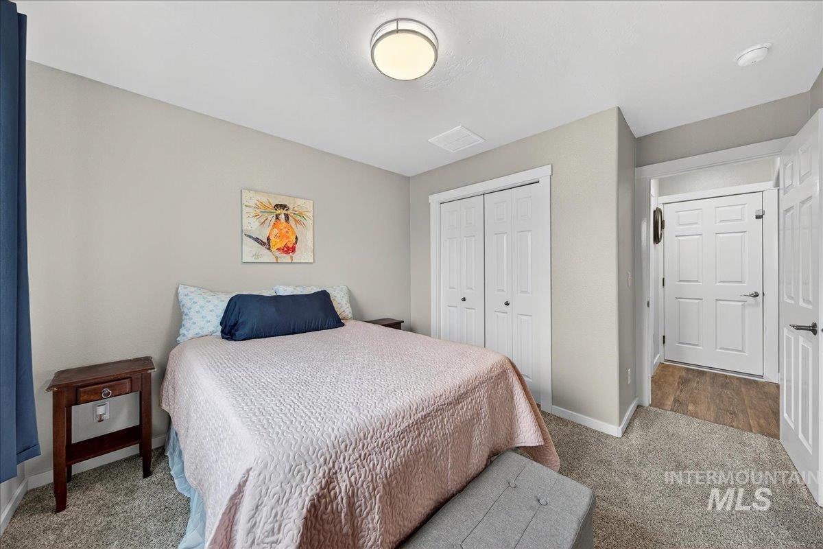 Carpeted bedroom with a closet and baseboards