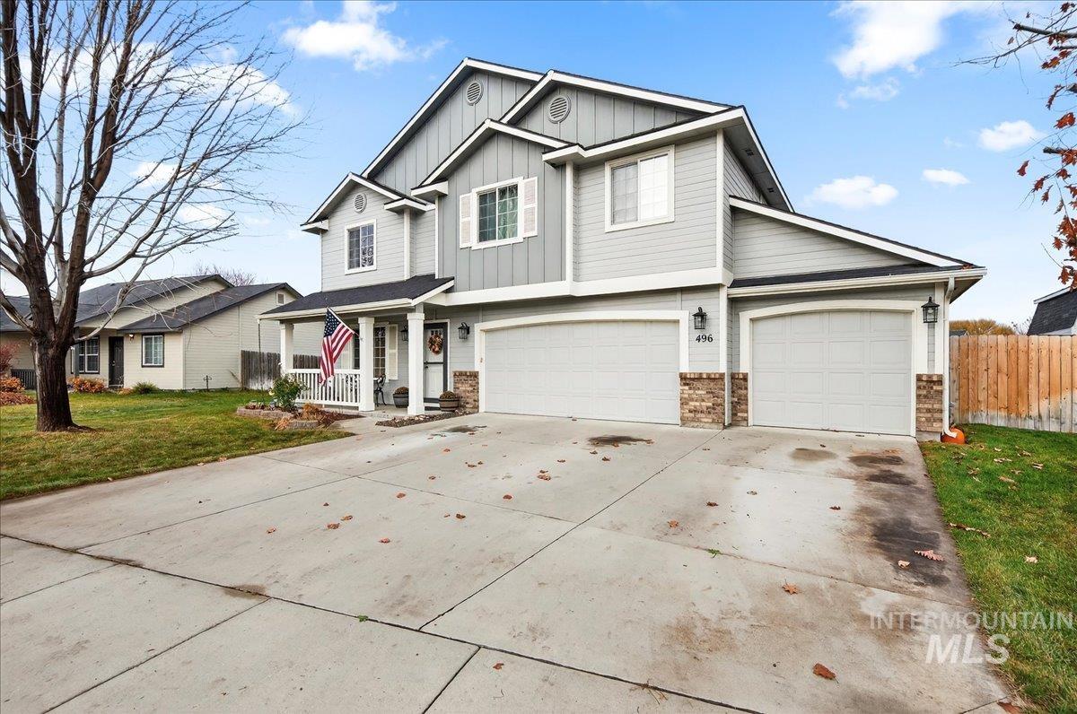 View of front of property featuring concrete driveway, board and batten siding, a garage, and covered porch