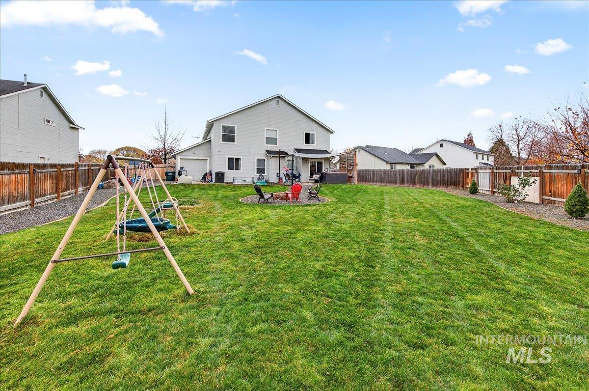 Rear view of property featuring a fenced backyard, a playground, and a patio area