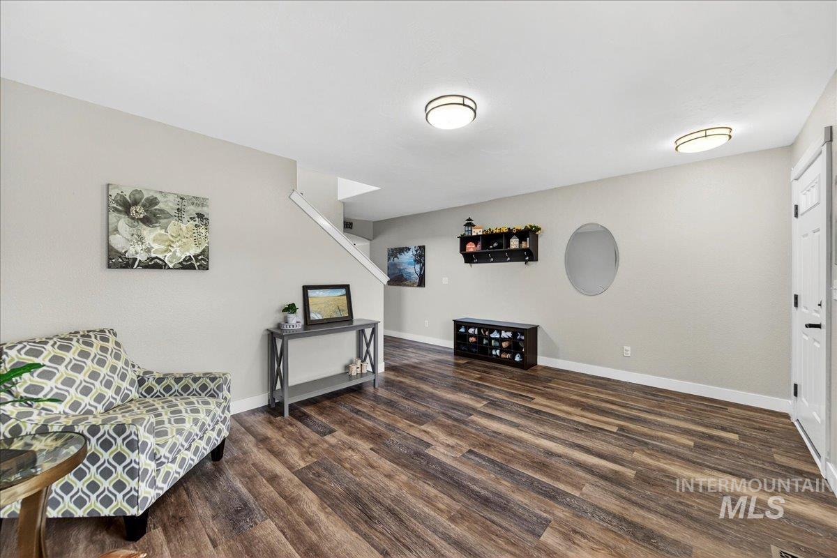 Sitting room featuring dark wood-style floors and baseboards