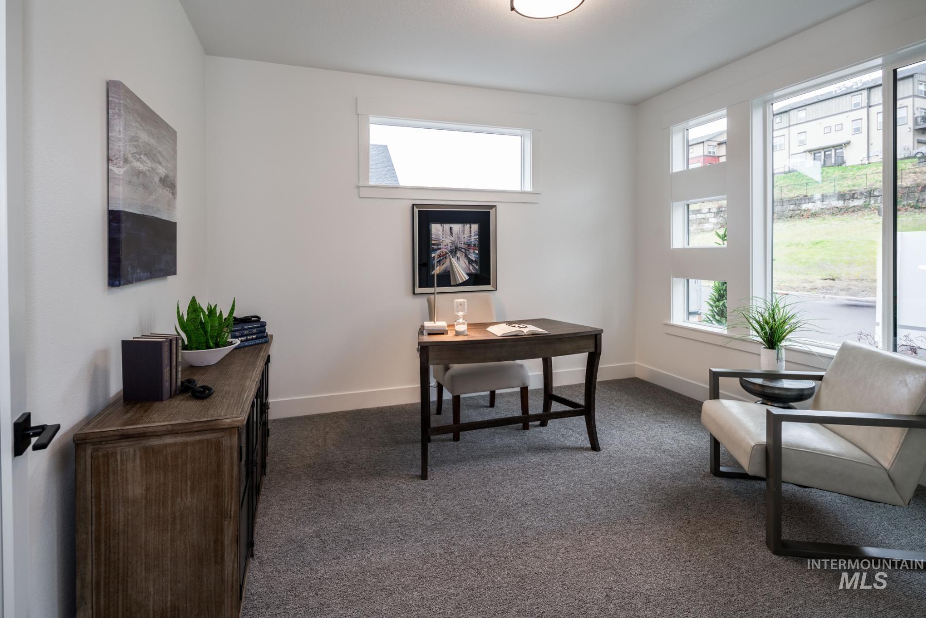 Office area with dark carpet and baseboards