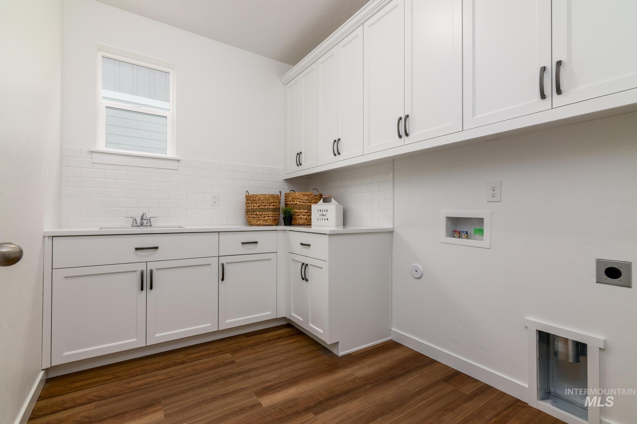 Laundry area featuring hookup for a washing machine, dark wood-style floors, cabinet space, and electric dryer hookup