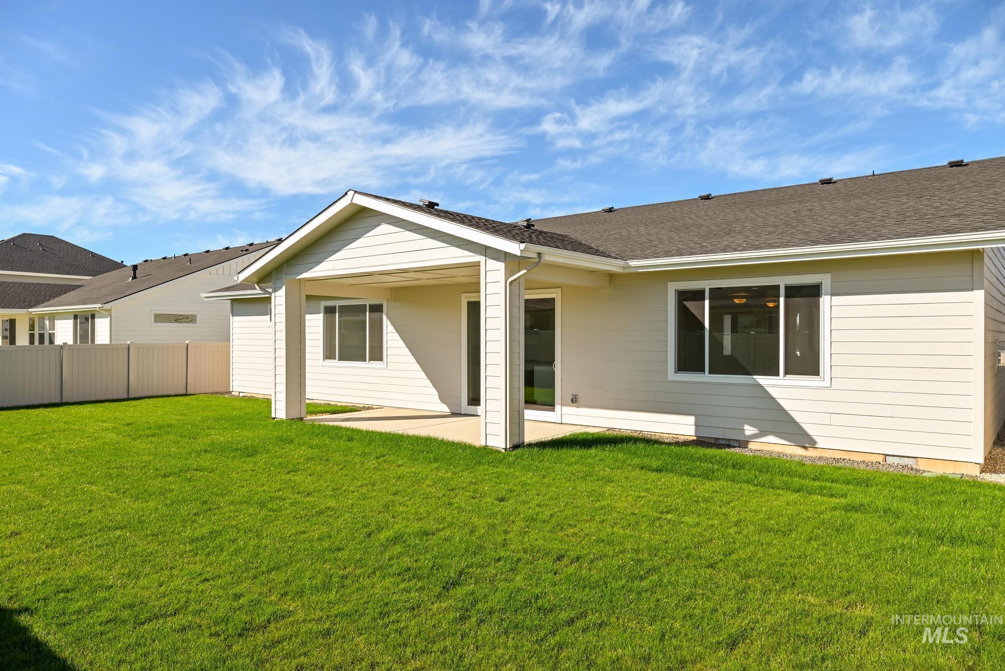 Rear view of property featuring a patio and a shingled roof