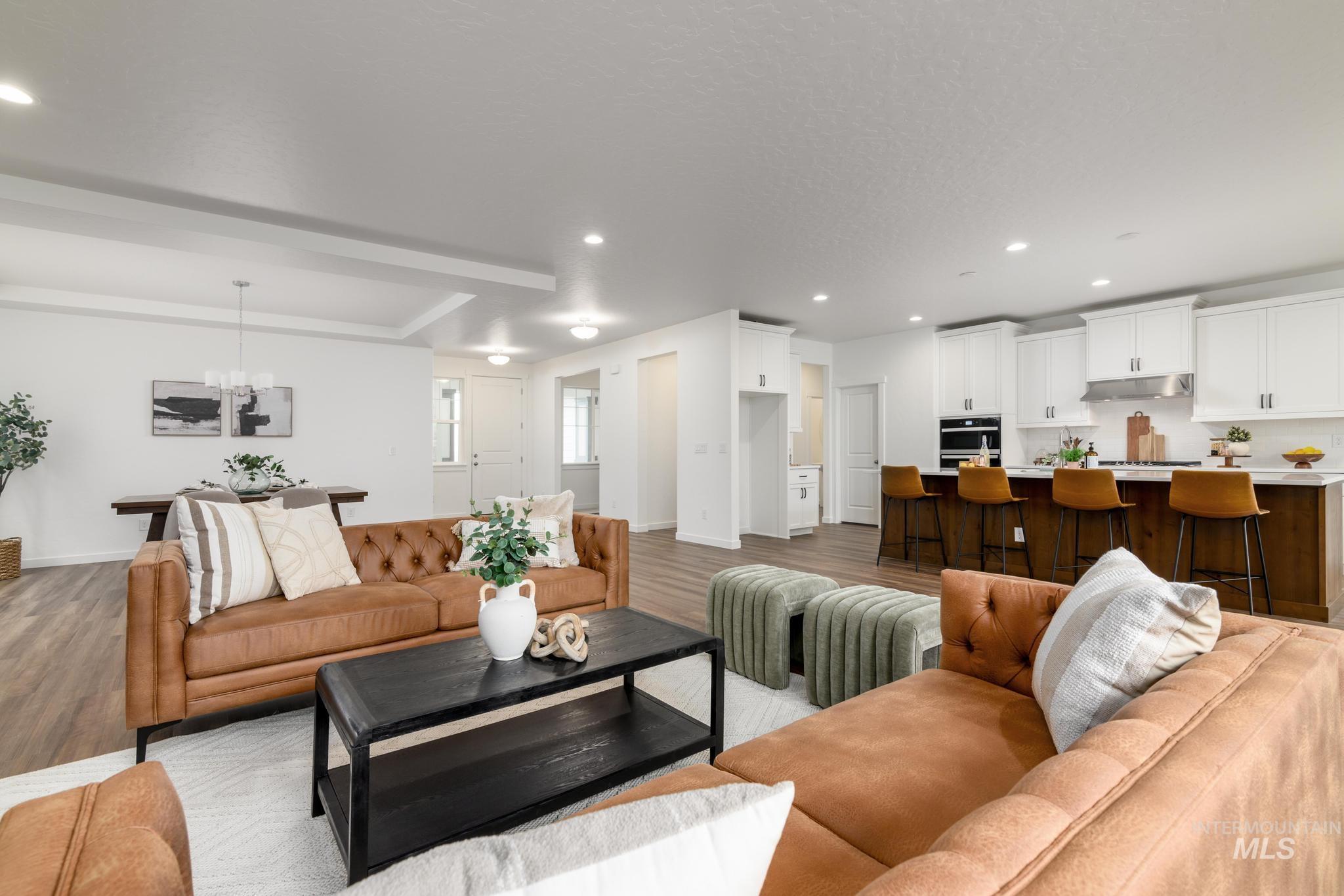 Living room with recessed lighting, light wood-style flooring, and a chandelier