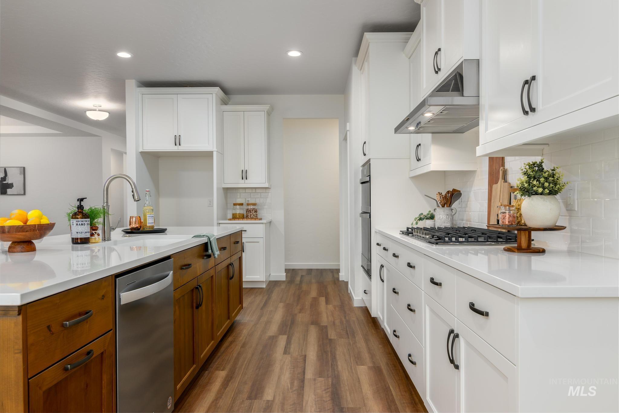 Kitchen with brown cabinets, white cabinetry, stainless steel appliances, and recessed lighting