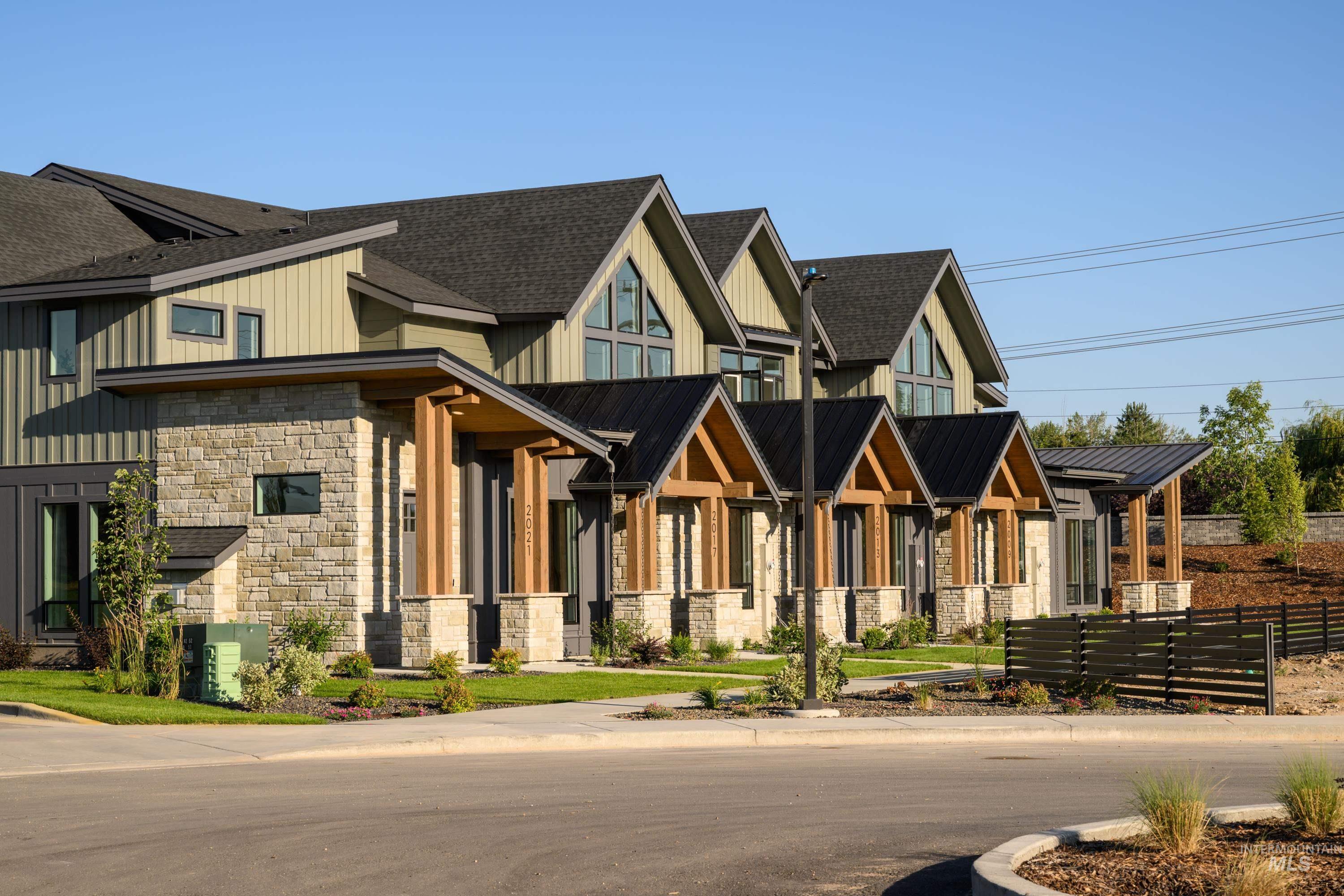 View of front facade with stone siding, board and batten siding, and a metal roof
