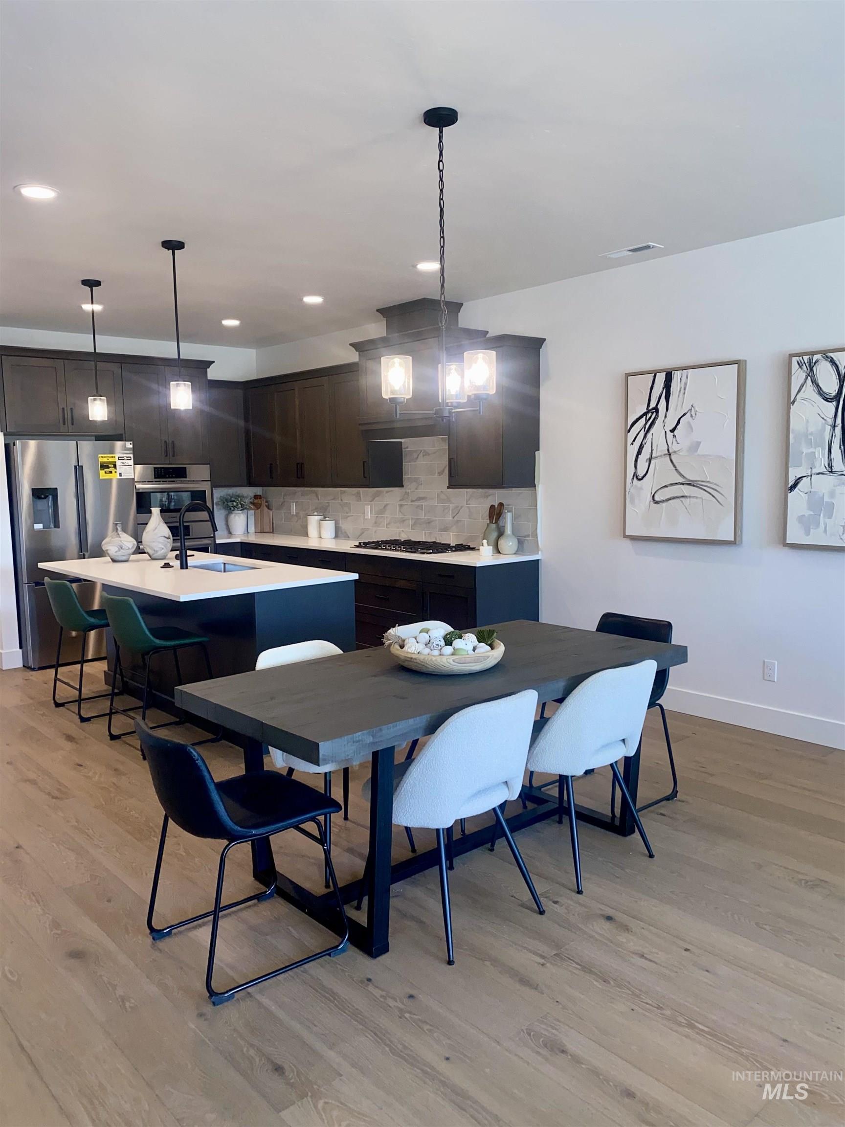 Dining area with light wood-style flooring, a chandelier, and recessed lighting