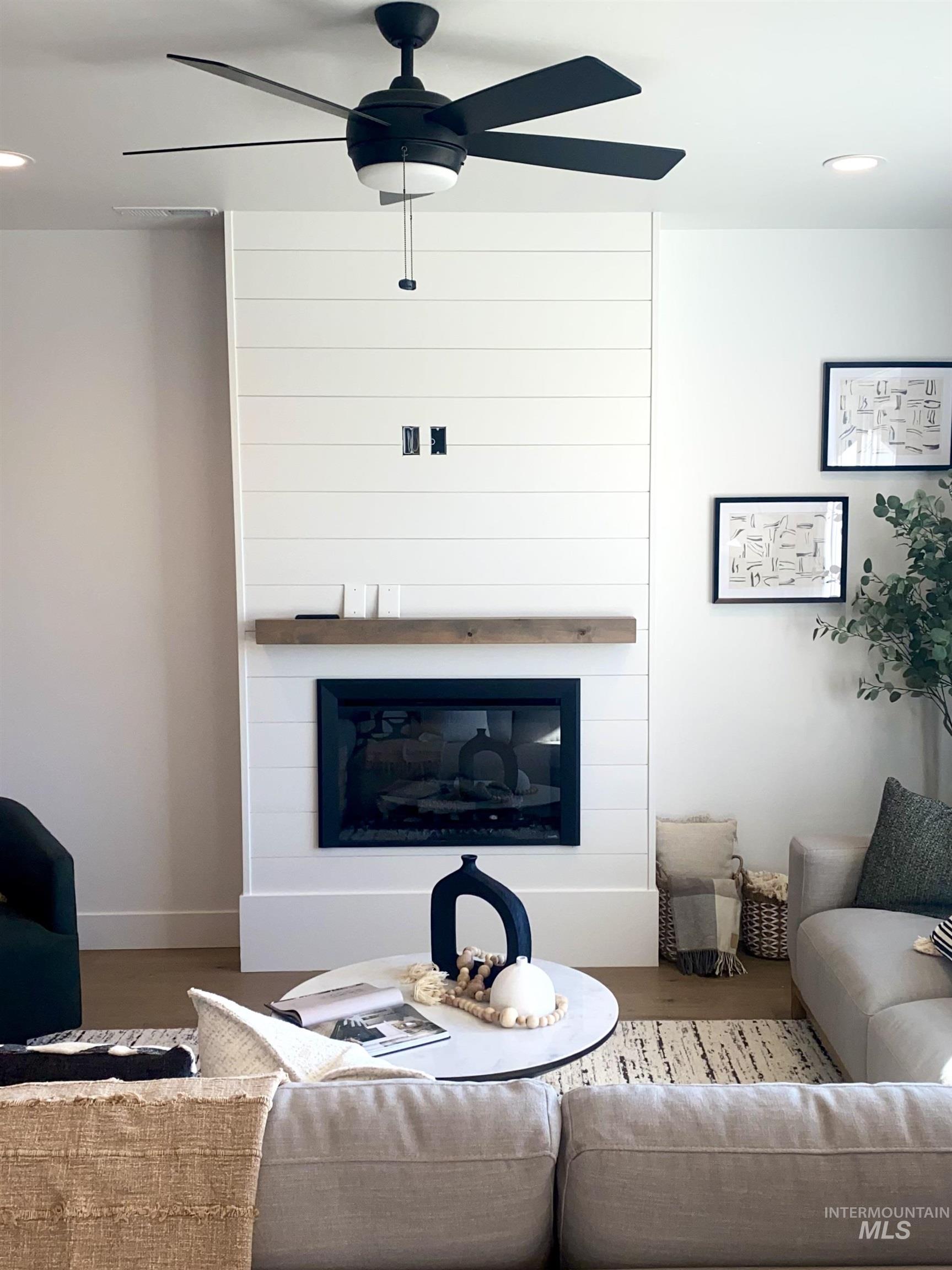Living room featuring recessed lighting, a fireplace, wood finished floors, and a ceiling fan