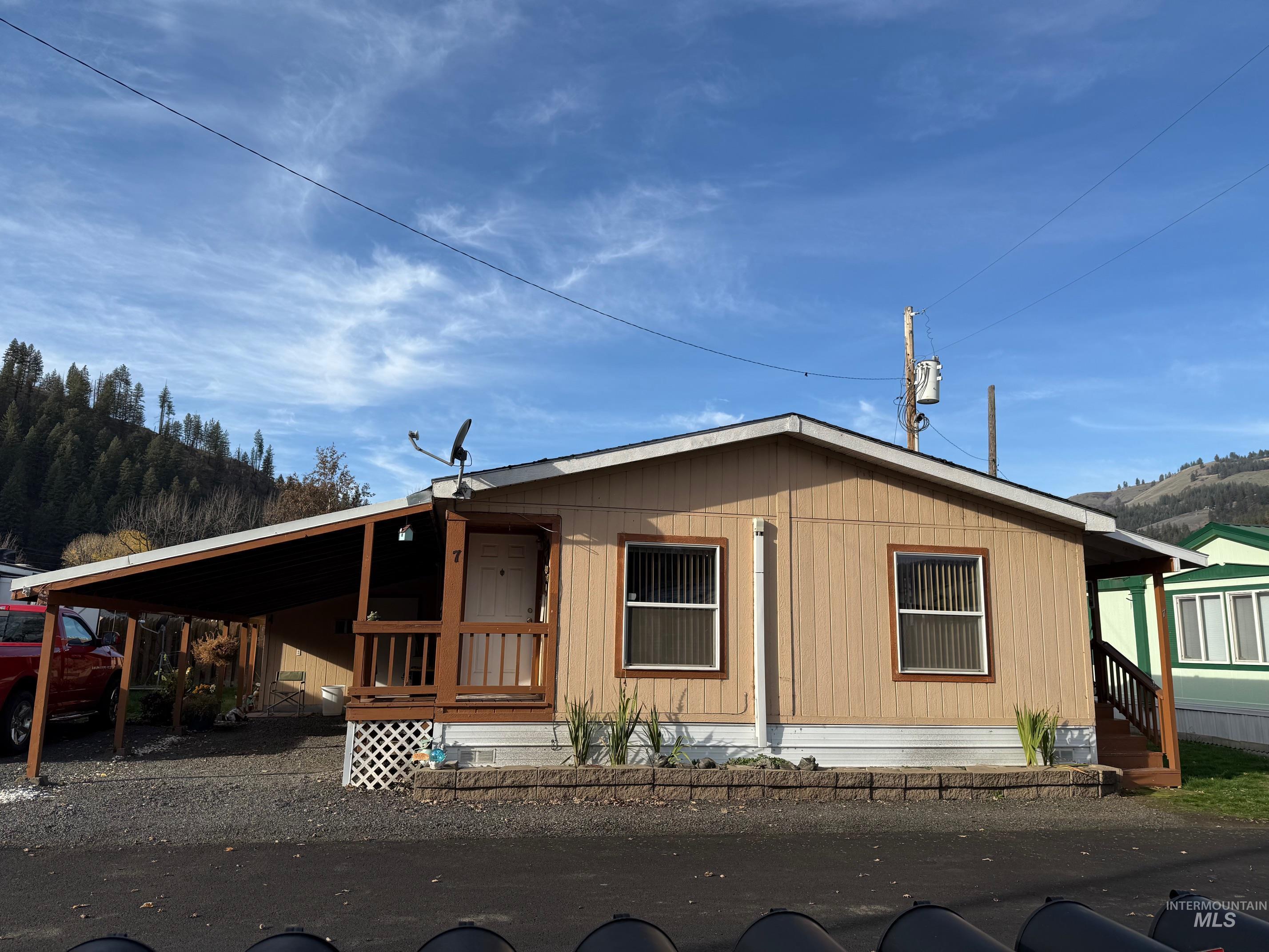View of front of property featuring an attached carport and a porch