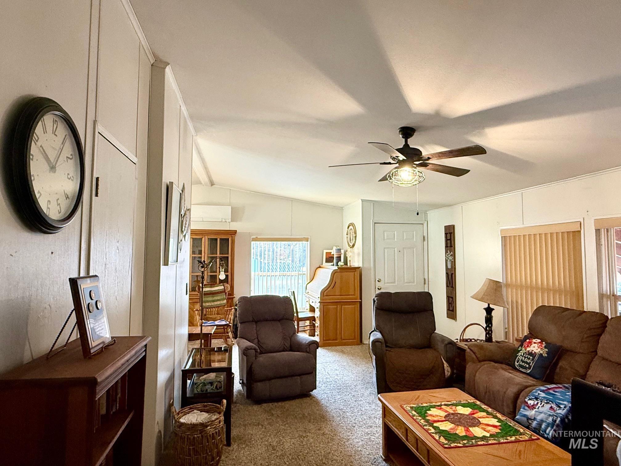 Living area featuring carpet, lofted ceiling, and ceiling fan