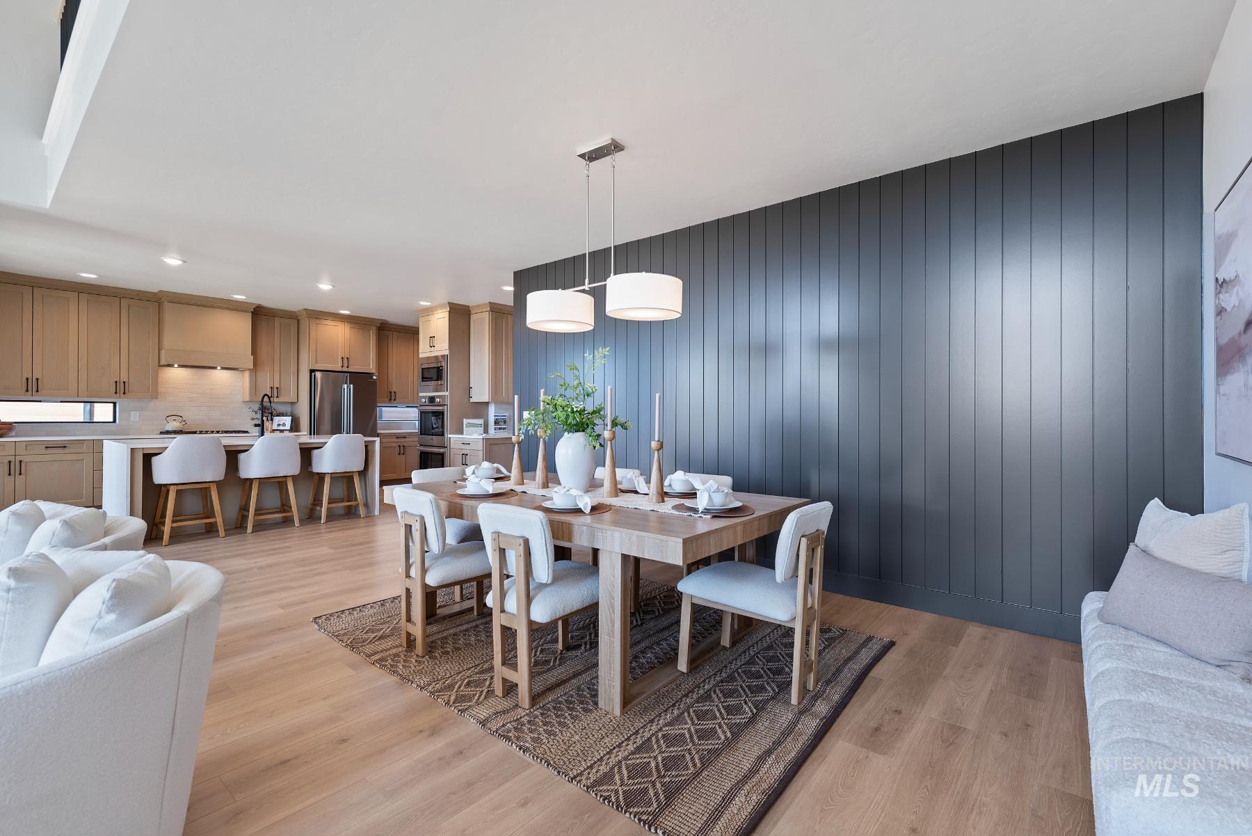 Dining room with light wood-style flooring and wooden walls
