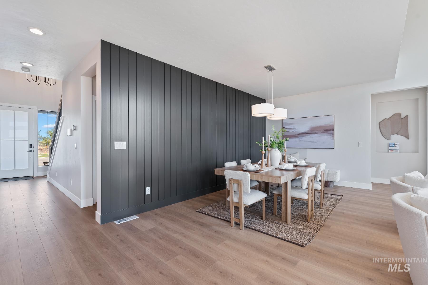 Dining area featuring an accent wall and light wood finished floors