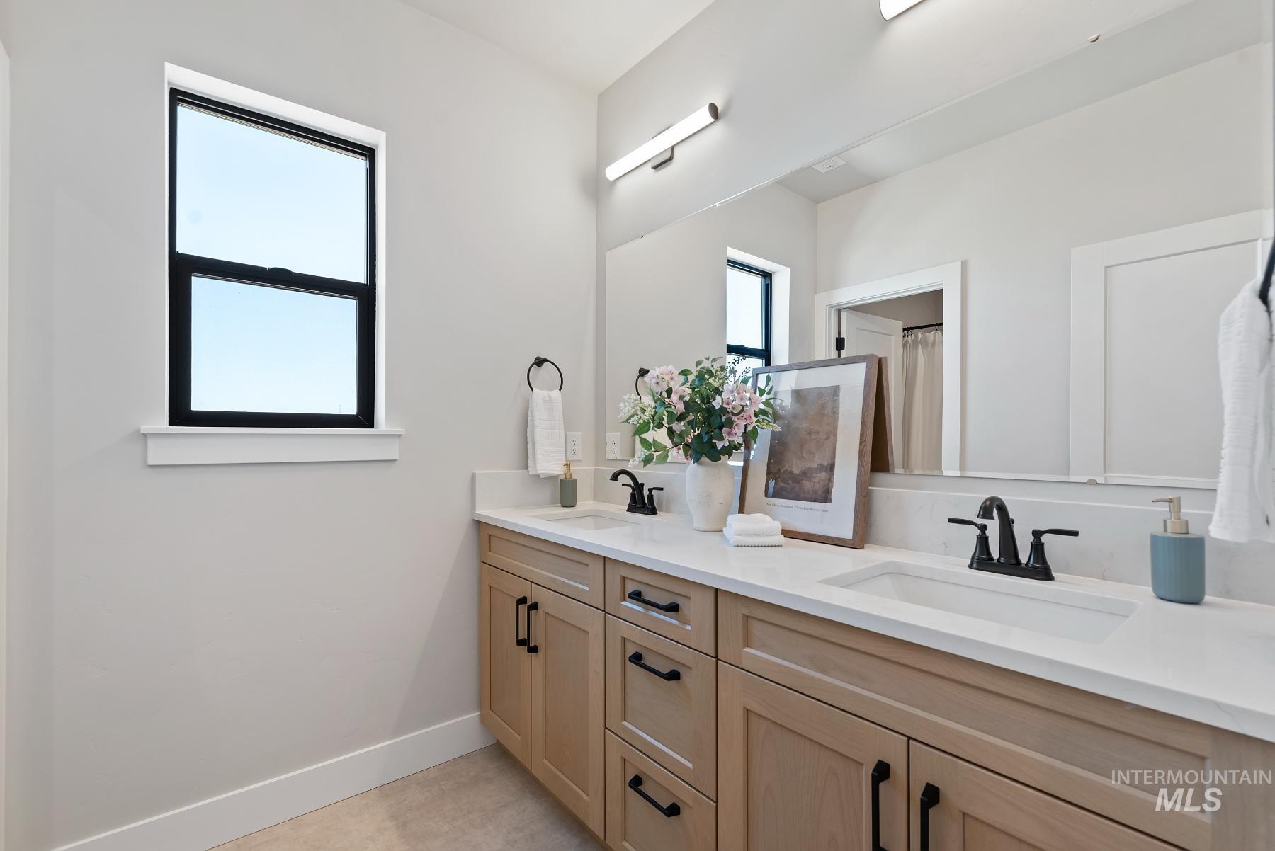 Bathroom with double vanity and a shower with shower curtain