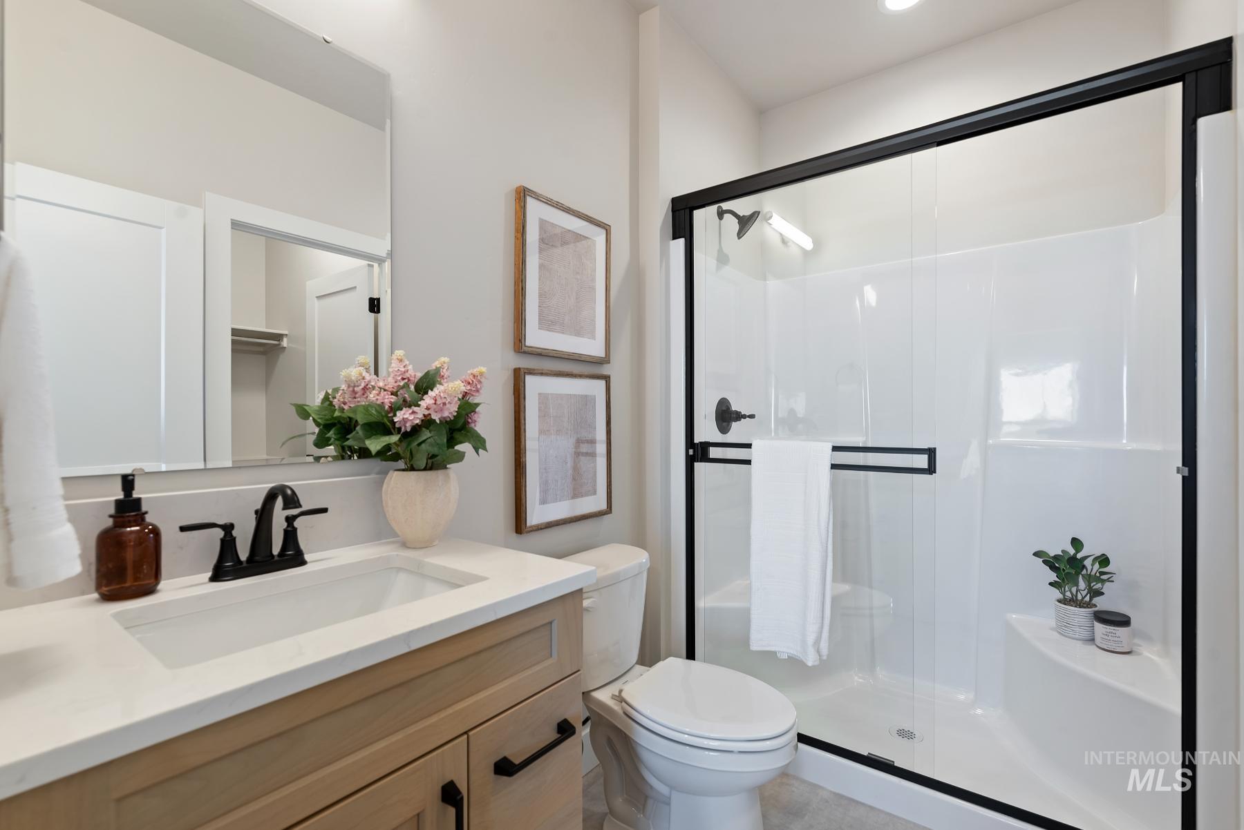 Full bathroom featuring a stall shower and vanity