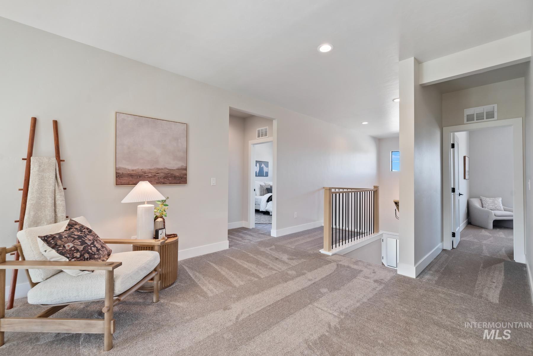 Living area featuring an upstairs landing, carpet floors, and recessed lighting