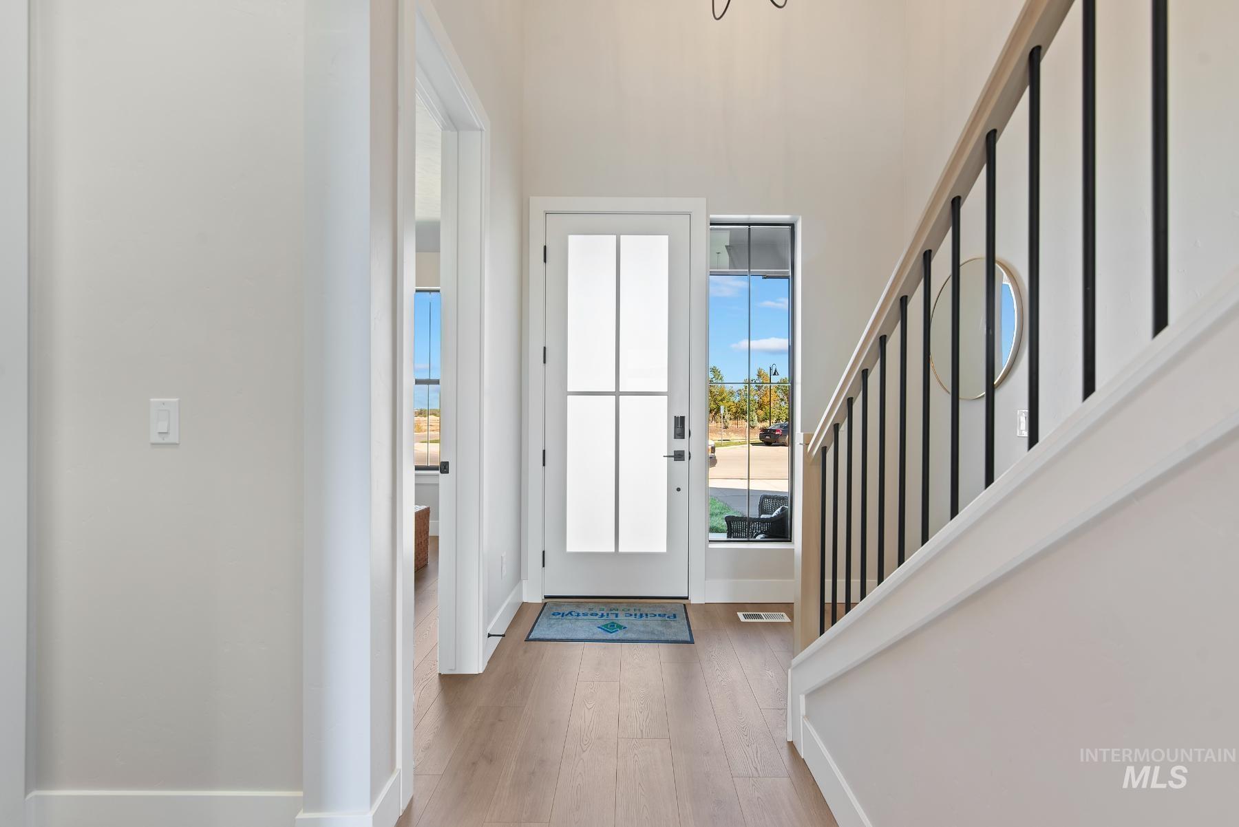 Entryway with light wood-type flooring and stairway